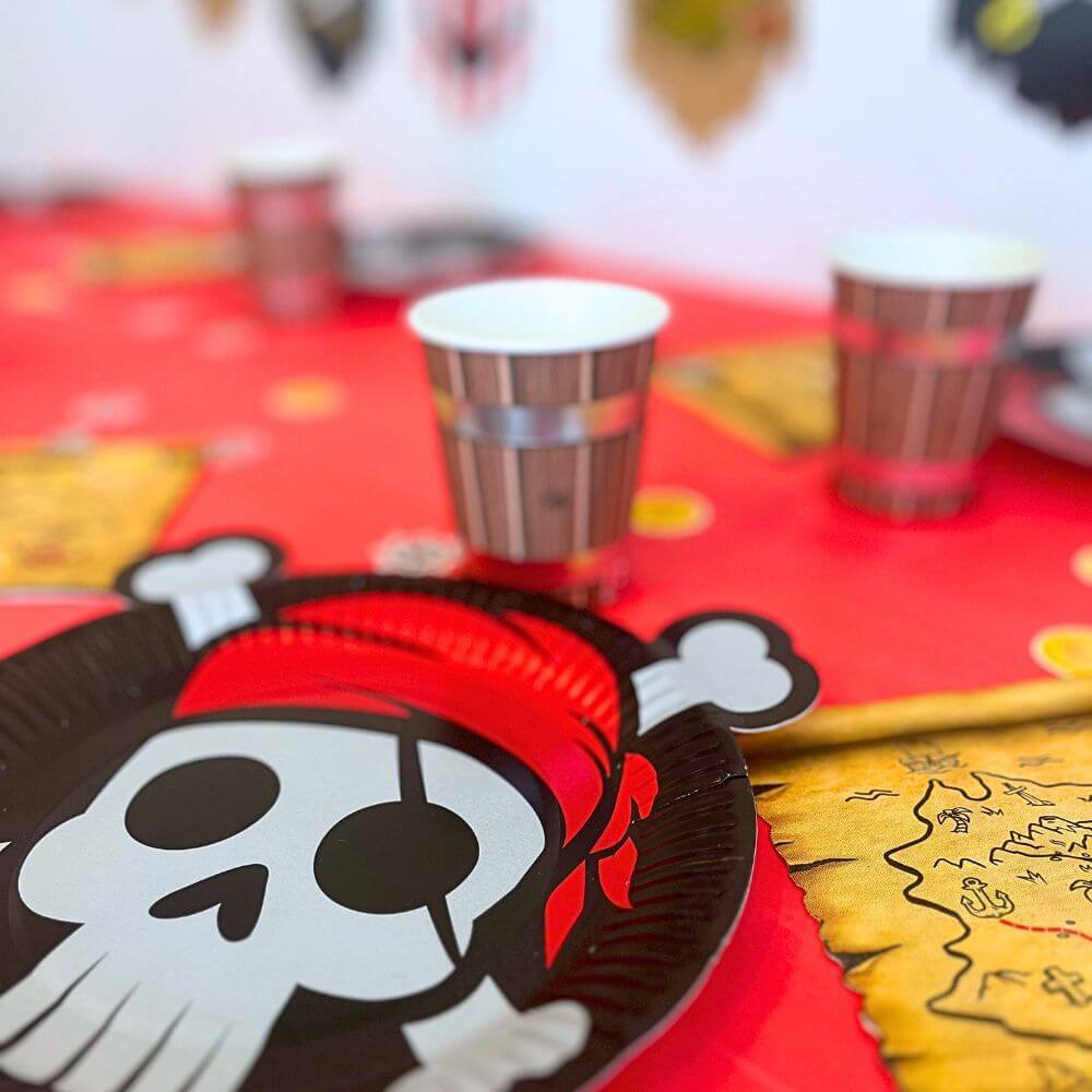 Box anniversaire Jimily : Décoration de table pour anniversaire enfant sur le thème des pirates : assiettes tête de mort, gobelets tonneaux et serviettes jetables en forme de carte au trésor pour une fête d'anniversaire remplie d'aventures.